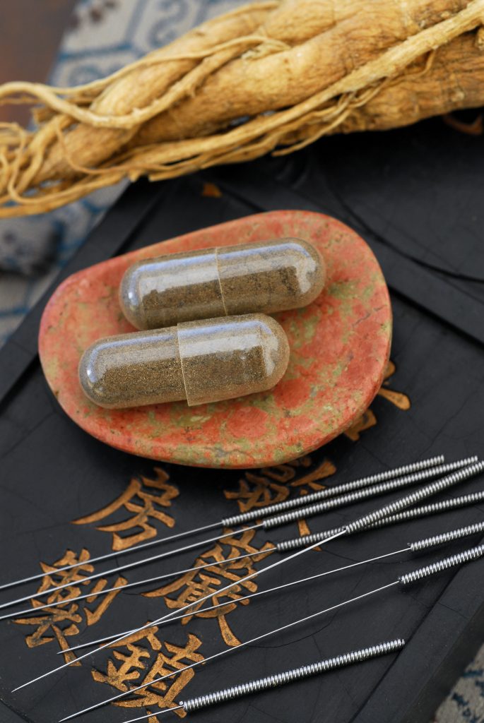 Photo of herbal medicine capsules and acupuncture needles